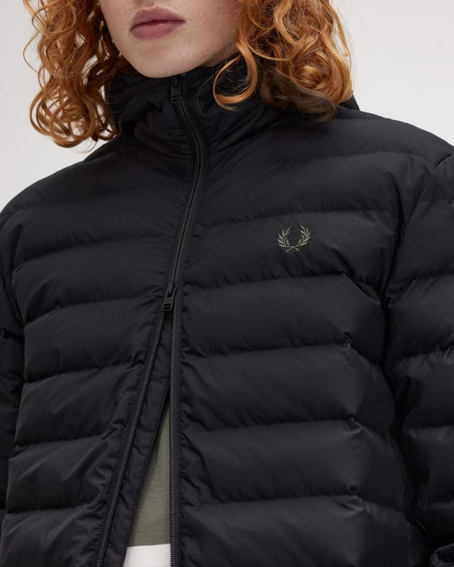 A staple Fred Perry insulated jacket with an adjustable hood and twin tipping to the internal collar.

Recycled polyester ripstop fabric 
Regular fit
Two way zip with branded puller 
Zip-up side seam pockets 
Laurel Wreath embroidered logo on the left hand chest

100% Recycled Polyamide
J8553