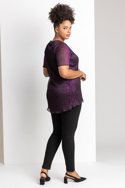 Curve Metallic Plisse Top from Roman. Add effortless glamour to your wardrobe this season with a shimmering ombré number. Cut with a flattering v-neckline and sheer short sleeve, this Curve blouse boasts a delicately pleated bodice and shimmer surface, giving it a beautifully feminine feel. Perfect to throw on over faux leather leggings or dress up in the evening, this ombre top is as versatile as it is striking. Ideal for your Christmas party, pair with the matching plisse cover-up jacket and some wide-leg trousers!