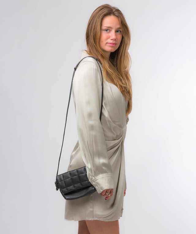 The 'Zoey' cross body bag from the Pure Luxuries London Marylebone Collection is handcrafted from high-quality, genuine Nappa leather with a natural super-soft touch. The fold-over top features an eye-catching quilted design and is secured by a magnetic press stud. The interior is lined with 100% cotton and includes two card slots, to help keep maintain an organised bag. Comes with an adjustable slim leather strap, with a drop length of 65cm. The Pure Luxuries logo is embossed in gold foil for a beautifully simple finishing touch.