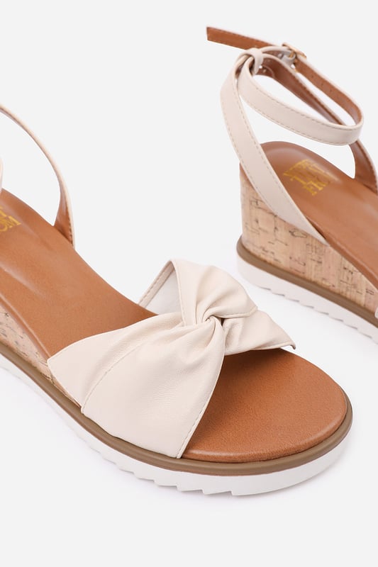 Wheres That From Womens 'Qween' Knot Detail Wedge Shoes With Buckle Ankle Strap Refine your summer style with Qween Knot Detail Wedge Shoes with Buckle Ankle Strap, designed to provide both comfort and sophistication. These sandals are versatile enough to complement casual and semi-formal outfits, making them an essential addition to your wardrobe.
Key Features:
Durable Construction: Crafted with a faux leather upper and a trendy knotted design, these sandals offer both a chic touch and long-lasting durability. The cork-textured wedge enhances the natural appearance, while the white ridged outsole adds modern flair and provides added traction.
Design: The open-toe style and adjustable ankle strap with a gold-tone buckle ensure a perfect fit and a contemporary look. The lightweight wedge adds a touch of height without compromising on comfort, making them perfect for all-day wear.
Comfortable Fit: With a softly cushioned footbed and a durable, non-slip sole, these wedges provide exceptional comfort and reliable support. They’re designed to keep you stylish and comfortable throughout the day.
Specifications:
Material: Faux leather upper with a trendy knotted design for a chic touch
Closure: Adjustable ankle strap with a gold-tone buckle for a perfect fit
Invest in our Qween Knot Detail Wedge Shoes with Buckle Ankle Strap and enjoy the perfect combination of style and comfort. Effortlessly pair these sandals with maxi dresses, tailored pants, or casual skirts for a polished and versatile summer look. These wedges are ideal for all-day wear while keeping you stylish!