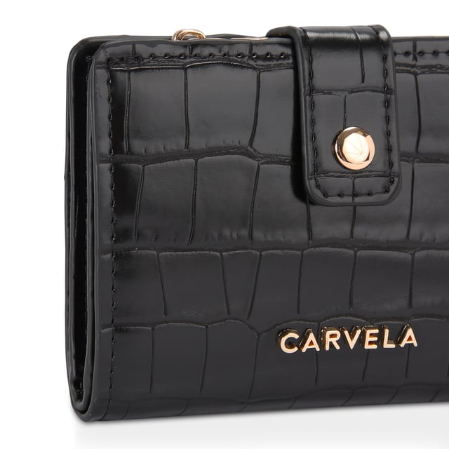The Carvela Mandy Purse features a black croc embossed exterior. There is a gold tone Carvela branding on the front and pop closure. Can fit classic credit cards. Dimensions: 9cm (H), 12cm (L), 3cm (D).