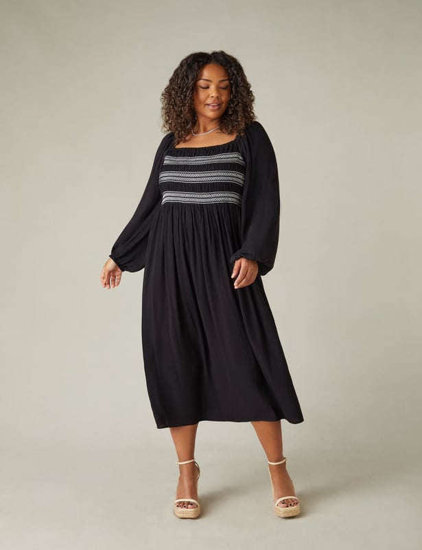 In classic black, this dress is cut from a soft, textured fabric thats so comfortable to wear. With elasticated shirring through the bodice in contrasting white, it has a flattering square-neck shape. Elastication around the neck and shoulder heads ensures comfort, while a cross-shoulder tie prevents the full-length sleeves from falling down. It has a stylish midaxi shape with a flowy skirt, making this the perfect warm weather piece.