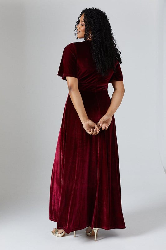 Luxurious velvet fabric for a sumptuous look and feel
        Flattering V-neckline to enhance the dcolletage
        Angel sleeves for a romantic and ethereal touch
        Floor-sweeping maxi length for a dramatic silhouette
        Fitted waist to accentuate the figure
    
    This enchanting V Neck Angel Sleeve Velvet Bridesmaids Maxi Dress from Coast is the epitome of sophistication and grace. Perfect for the bridal party, this gown is designed to complement the bride while ensuring you stand out in your own right. The sumptuous velvet fabric drapes beautifully, creating a fluid silhouette that moves elegantly as you walk. The angel sleeves add a whimsical touch, while the V-neckline draws attention to the dcolletage. The fitted waist cinches in to create an hourglass shape, flowing into a full-length skirt that skims the floor. Pair with delicate strappy heels and minimal jewellery to let the dress take centre stage. This gown is versatile enough to be worn again for other formal occasions, making it a treasured addition to your wardrobe long after the wedding bells have rung.