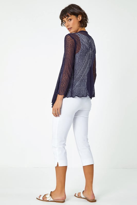 Textured Pointelle Detail Shrug from Roman. Your new favourite layer for cooler days, this handy little shrug will become your go-to cover-up for any occasion this Summer. Made from a soft feel pointelle yarn, this lightweight shrug features 3/4 sleeves and finishes at a cropped length with an elongated front. Perfect for layering over dresses in the evening, this scalloped edge cardigan is destined for cruise ships, beach bars and beyond!