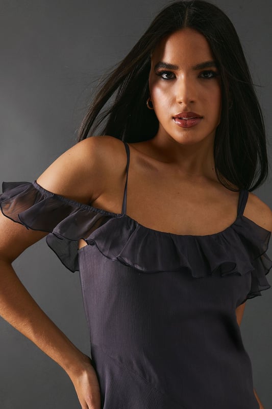 Add a touch of elegance to any occasion. With its embellished asymmetric ruffle and strappy design, it offers a unique and stylish look. The midaxi length adds a modern twist, making it perfect for both casual and formal events.
