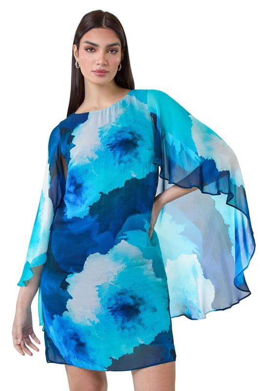 Floral Print Chiffon Cape Shift Dress from Roman. Make a statement this season in our elegant, Ariella collection chiffon cape dress. This stunning piece is perfect for those special events with its modest round neckline and secure zip fastening. The whimsical cape sleeves add a touch of drama to the classic shift shape, while the beautiful floral print exudes femininity. The draped chiffon fabric floats gracefully as you move, making you feel like a true belle of the ball! Whether you're attending a wedding or a formal dinner, style with strappy heels and a clutch bag for a look that's sure to turn heads!