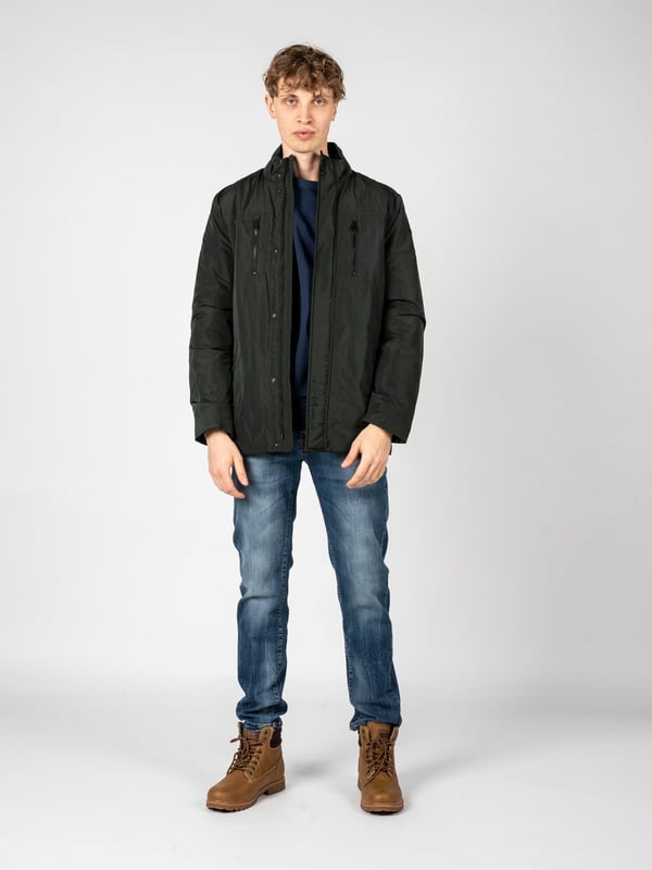 El estilo sencillo es la combinación perfecta de clásico y moderno, lo que hace que esta chaqueta se adapte perfectamente a diversos estilos, desde casual hasta más elegantes, manteniendo su carácter único y minimalista.

En el cuello alto, que añade elegancia a la chaqueta y proporciona protección adicional contra el viento, puedes confiar en los días más fríos, y su diseño sutil hace que la chaqueta gane en universalidad y sea ideal para cualquier ocasión.

Con una capucha oculta en el cuello, este elemento práctico permite una rápida adaptación a los cambios del tiempo, ofreciendo protección contra la lluvia cuando más lo necesitas, sin renunciar a la estética.

Cerrada con una cremallera logotipada y botones a presión, la chaqueta no solo proporciona un cierre seguro y cómodo, sino que también constituye un acento elegante, que subraya sutilmente su carácter de marca.

En el frente, cuatro bolsillos con cremallera ofrecen no solo mucho espacio para los elementos esenciales, sino también garantizan la seguridad de los objetos almacenados, permitiéndote disfrutar de plena funcionalidad y comodidad diaria.

Ajustable con cordones en la cintura, la chaqueta permite un ajuste perfecto al cuerpo, lo que no solo resalta su aspecto moderno, sino que también proporciona confort adicional, adaptándose a tus necesidades individuales.

En la manga izquierda, un detalle de la marca constituye una referencia sutil, pero clara, a la marca, añadiendo prestigio a la chaqueta y destacando su exclusividad, lo que seguramente atraerá la atención de aquellos que valoran los detalles de marca.

Hecha de un tejido de alta calidad, transpirable y resistente al agua, la chaqueta no solo proporciona comodidad térmica y protección contra la humedad, sino que también cuida la adecuada circulación del aire, lo que la hace una opción ideal para diversas condiciones climáticas.