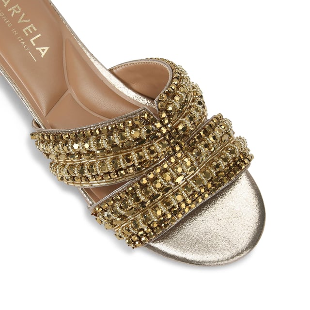 This Carvela Pageant Mule sandal is crafted from a metallic gold fabric and each of the two straps are embellished with statement gold crystals.