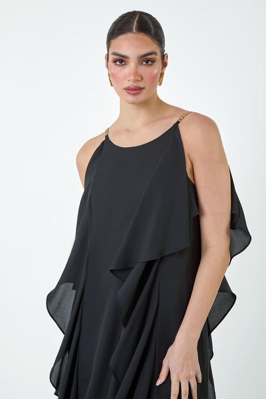 Plain Dipped Hem Ruffle Detail Midi Dress from Roman. Elevate your Summer wardrobe with this striking ruffle detail midi dress from the Ariella range. Featuring a elegant, cascading waterfall ruffle detail, this dress has a striking hi-low silhouette to add a touch of drama to your occasionwear. This sleeveless dress with a concealed back zip fastening is crafted from plain woven fabric and fully lined for maximum comfort. The metal trim on the shoulder straps provides a sophisticated edge. Whether you're attending a wedding or a formal dinner, style it with strappy heels and a clutch bag for event-ready glamour!