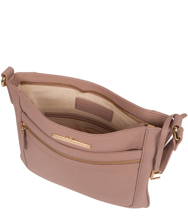 The 'Lewes' cross body bag from Pure Luxuries London, is crafted from naturally milled leather with a beautifully distinct fine-grain feel. A zip-over top secures a gorgeous, 100% natural cotton-lined interior with two slip pockets. On-the-go storage comes in the form of an exterior zipped pocket and two slip pockets, complemented by an adjustable and matching leather shoulder strap. Furnished with gold coloured metal fittings and the elegant Pure Luxuries London charm and logo plate.