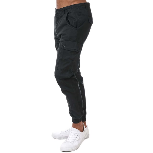 Pantalones cargo ajustados para hombre Jack Jones Paul Warner en negro. - Cierre de botón. - Bolsillos laterales. - Bolsillos con botón en la parte trasera y en las piernas. - Lavado enzimático ecológico que proporciona un aspecto desgastado. - Prenda de tejido de sarga con elasticidad. - Marca en la parte trasera. - Puños acanalados. - Ajuste entallado. - Material principal: 98% algodón 2% elastano. Lavable a máquina. - Ref: 12167596