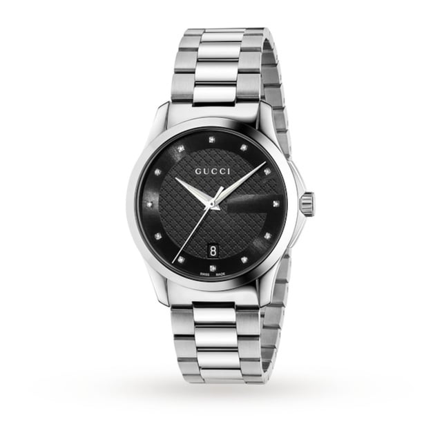 With the polished to perfection silhouette and diamond details, Gucci introduce the G-Timeless Diamond Date watch, the ultimate luxury accessory that you will never want to take off. Showcasing the same design flair as they do with their clothes, it's distinguishable by its round, 38 mm case and carefully crafted from highly polished and brushed stainless steel. Inside the case, the black dial has a subtle diamond checkerboard effect in the centre and an understated 'G' logo bordering the outer rim. Complemented by twelve diamond-set indexes that sparkle when it moves, steel-toned, sword-shaped hour and minute hands and a slim seconds hand. A date window is located at the 6 o'clock position, adding functionality to form and keeping you punctual in your daily routine. The iconic Gucci logo ensures the stamp of quality and it's all protected by a sapphire crystal glass cover. The bezel, lugs and three-link bracelet co-ordinate in polished and brushed steel, it's filled with character and fastens with a deployment buckle for a secure and comfortable fit. Powered by Swiss quartz technology, it's extremely accurate and has a 50 m water resistance, which is ideal for every day wear. Reflecting the spirit of luxury, the G-Timeless Date will keep you on time and on-trend, making it the perfect accompaniment for either night or day. Shine bright and add diamonds to your everyday wear with Gucci
