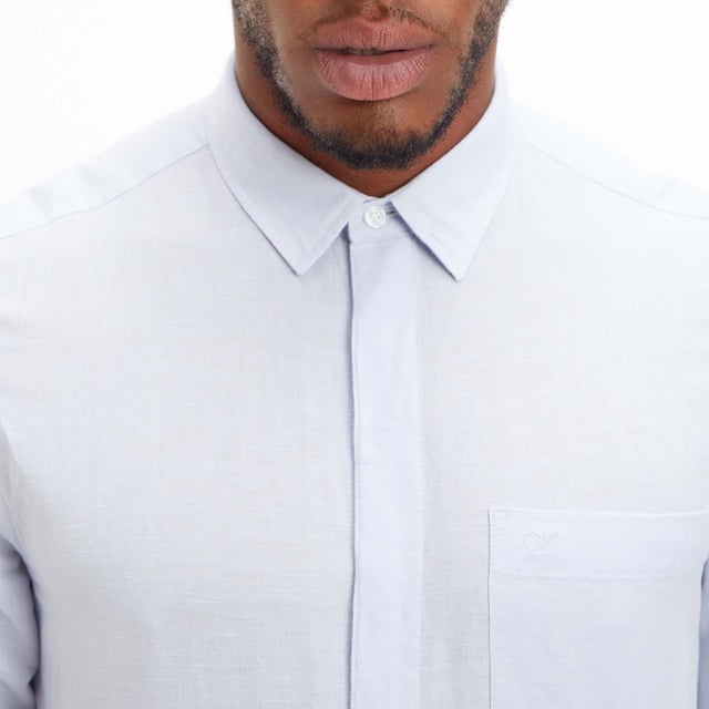Mens Calvin Klein Regular-Fit Linen Cotton Shirt in blue.- Pointed collar.- Long sleeves with buttoned cuffs.- Concealed button fastening.- Patch chest pocket with Calvin Klein tonal monogram.- Regular fit.- Ref: K10K108664C3N