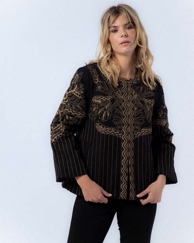La Chaqueta Diana es una pieza clave para tu armario de otoño. Con su elegante diseño bordado y corte holgado, esta chaqueta ofrece un estilo sofisticado y moderno. Combínala con pantalones oscuros y tacones para un look chic y profesional.
 
 
 
 Chaqueta acolchada con cuello redondo.
 
 Manga larga.
 
 Bordado a máquina y a mano en delantero, espalda y mangas.