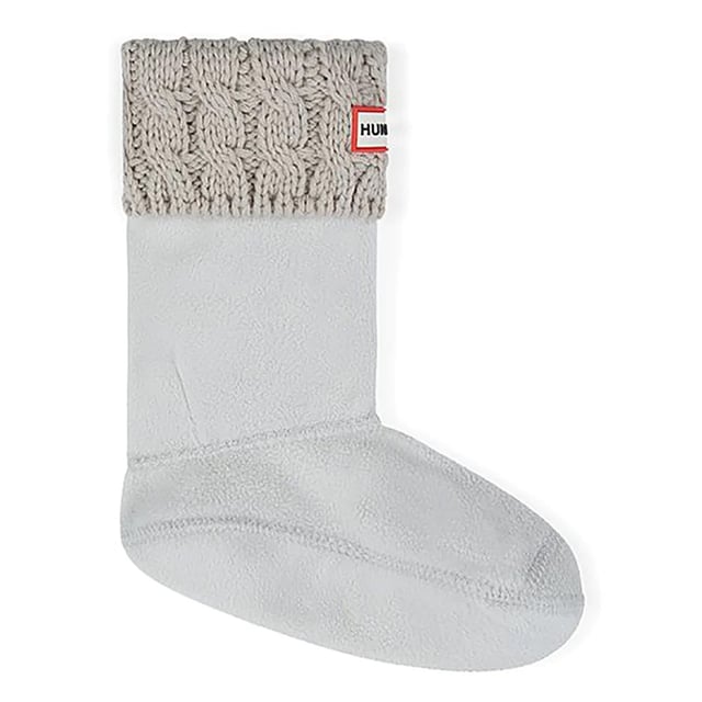 Los calcetines Hunter Original Cable Cuff Tall Kids White Boot Socks son una adición encantadora al armario de los niños para los días de lluvia, diseñados para complementar sus botas Hunter. Con un encantador diseño de puño de cable y un limpio color blanco, estos calcetines proporcionan estilo y comodidad a los jóvenes aventureros.

Características principales:

 Diseño de puño de cable:  El diseño de puño de cable añade un toque caprichoso y clásico a estos calcetines de bota para niños, aportando un elemento de moda a su conjunto para los días de lluvia.

 Color blanco: El color blanco es nítido y versátil, lo que permite que estos calcetines combinen a la perfección con varios estilos de botas Hunter y diferentes conjuntos.

 Largo de bota alta:   Diseñados para las botas Hunter de los niños, estos calcetines cubren por encima de la caña de la bota, proporcionando calor y un detalle de estilo.

 Material de primera calidad:   Fabricados con materiales de alta calidad, los calcetines ofrecen un tacto suave y cómodo sobre la piel de los niños, garantizando una agradable experiencia de uso.

 Marca icónica:   Busque el sutil logotipo o marca Hunter en el calcetín, que refleja la autenticidad y calidad asociadas a la marca Hunter.

 Calidez y aislamiento:   Ideales para climas más fríos, los calcetines con puño de cable proporcionan aislamiento adicional, manteniendo los piececitos calientes y acogedores en temperaturas más frías.

 Puño de canalé:   El puño acanalado garantiza un ajuste seguro y añade un detalle juguetón a la parte superior de los calcetines, evitando que se deslicen hacia abajo durante el juego.

Consejos de estilo:

Deja que el dibujo del puño de canalé asome justo por encima de las botas Hunter del niño, añadiendo un elemento encantador y texturizado a su look general.

Combina estos calcetines blancos con puño de cable para niños altos con unas botas Hunter para conseguir un conjunto coordinado y a la moda, perfecto para las aventuras saltando charcos.