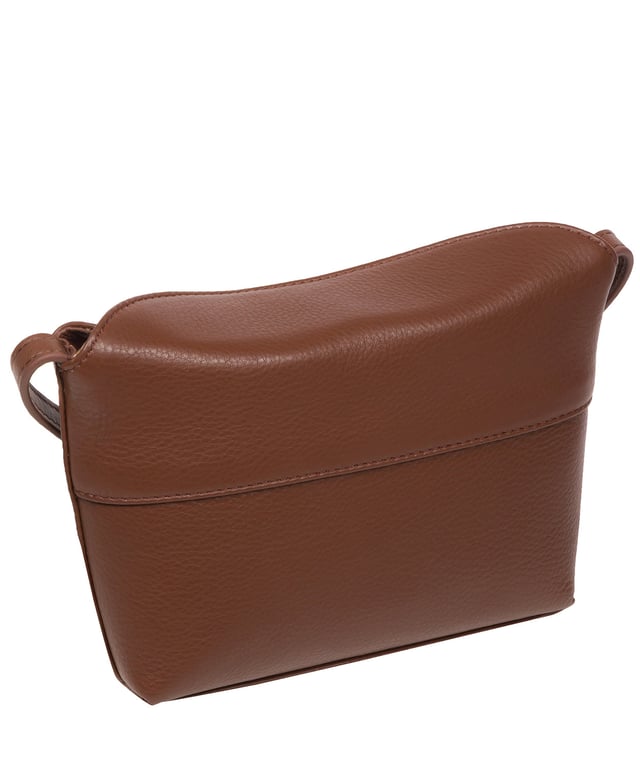 The 'Lolo' cross body bag from the Pure Luxuries Marylebone collection is handcrafted from high-quality, genuine Nappa leather with a natural super-soft touch. The bag is secured by a magnetic closure which opens to reveal a 100% cotton-lined interior and includes two slip pockets. Features gold-coloured metal fittings alongside the adjustable slim leather strap, with a maximum drop length of 65cm. The Pure Luxuries logo is embossed in gold foil for a beautifully simple finishing touch.