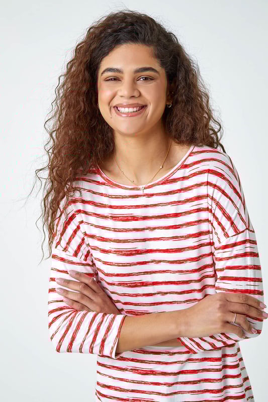 Abstract Stripe Print Stretch Top from Roman. Stripe it lucky this Spring with our newest casual top. Keeping the warmer weather in mind, this striped top is cut from a lightweight stretch jersey for a comfortable style that’s designed for all day wear. It has a modest round neckline, 3/4 length sleeves and a playful hanky hemline that makes it great for transitioning into the new season. A broken stripe print adds a new twist to the timeless nautical trend. Wear with jeans and trainers for the perfect Summer day style.