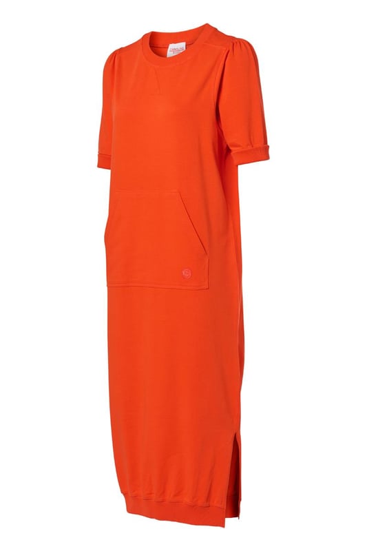 Ervaar de perfecte balans tussen stijl en comfort met deze prachtige lange sweaterjurk in een levendige oranje tint, een absolute must-have uit de collectie van Caroline Tensen. Dit veelzijdige kledingstuk combineert moeiteloos elegantie met ultiem draagcomfort. Gemaakt van 100% katoen, voelt de zachte sweaterstof heerlijk aan op de huid en biedt het een comfortabele pasvorm die je het liefst de hele dag draagt. De jurk is voorzien van subtiele pofmouwen en ribboorden bij de mouwen, kraag en zoom, wat zorgt voor een speelse en charmante uitstraling. Een extra praktisch en stijlvol detail is de kangoeroezak met verfijnd borduurwerk. Op de rug bevindt zich bovendien een uniek borduursel, geïnspireerd door de persoonlijke tatoeage van Caroline Tensen. Met zijn lange, vloeiende pasvorm en opvallende oranje kleur geeft deze jurk een frisse en vrolijke touch aan elke outfit. Of je nu geniet van een ontspannen dag thuis, een wandeling maakt in het park of een casual uitje hebt gepland, deze sweaterjurk is de perfecte keuze. Verrijk je garderobe met dit veelzijdige item en geniet van een ongeëvenaarde mix van stijl en comfort!