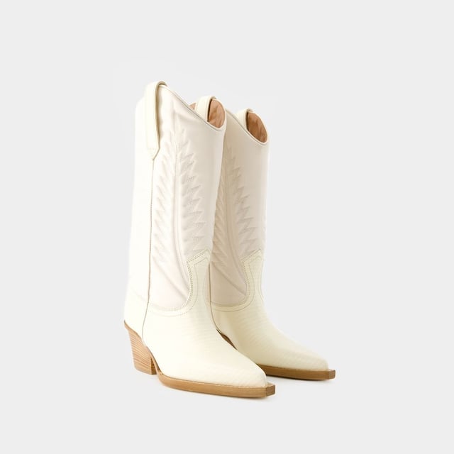 Permítanos presentarle las botas Rosario 60 de Paris Texas, donde la moda de alta gama se une al encanto contemporáneo. Estas botas son una impresionante mezcla de estética lujosa y diseño moderno, que te ofrece una opción sorprendente para mejorar tu colección de calzado. Piensa en las botas Rosario 60 como la pieza central de tu conjunto de moda. Combínalas con una falda midi fluida, un jersey entallado de cuello alto y accesorios de statement para conseguir un look a la última, perfecto para las inauguraciones de galerías o para una noche en la ciudad. Paris Texas Las botas Rosario 60 ejemplifican el compromiso de brand con la excelencia y el estilo, ofreciéndote una opción de calzado excepcional que combina a la perfección la sofisticación clásica con el encanto contemporáneo. Sal con confianza, mostrando tu sensibilidad única por la moda y la cautivadora elegancia de estas botas. Altura del tacón: 6 cm. Colores: Blanco - Hueso. Material principal: piel de becerro repujada en lagarto. Material de la suela: cuero. Material del forro: cuero. Cierre: fácil de poner. Forma de la punta: punta puntiaguda. Ajuste: fiel a la talla - Tallaje: europeo.