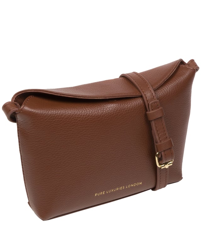 The 'Lolo' cross body bag from the Pure Luxuries Marylebone collection is handcrafted from high-quality, genuine Nappa leather with a natural super-soft touch. The bag is secured by a magnetic closure which opens to reveal a 100% cotton-lined interior and includes two slip pockets. Features gold-coloured metal fittings alongside the adjustable slim leather strap, with a maximum drop length of 65cm. The Pure Luxuries logo is embossed in gold foil for a beautifully simple finishing touch.