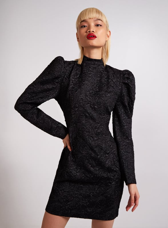 If you want to make an entry this season this dress is the one to do it in. Featuring a embossed black fabric, a high neck design with long sleeves and a flattering cut. Composition: 100% Polyester. Wash care: Machine Washable.