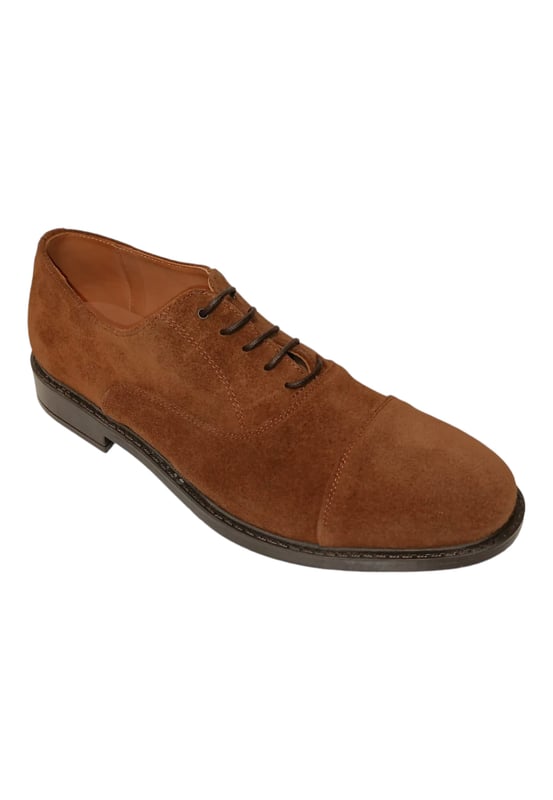Zapato cerrado de caballero con cierre de cordones, detalles de costuras en su superficie de serraje y acabado en punta. Cuenta con una cómoda suela y ligero tacón.