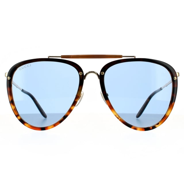 Gafas de sol aviador para hombre Gucci Havana azul. Las gafas Gucci tienen un estilo aviador femenino, elaboradas en acetato ligero con detalles metálicos contrastantes. Las lentes de poliamida en forma de lágrima están enmarcadas en plástico, con una barra superior distintiva, puente metálico y almohadillas nasales ajustables. Las patillas metálicas súper delgadas están terminadas con un grabado del logo de Gucci.