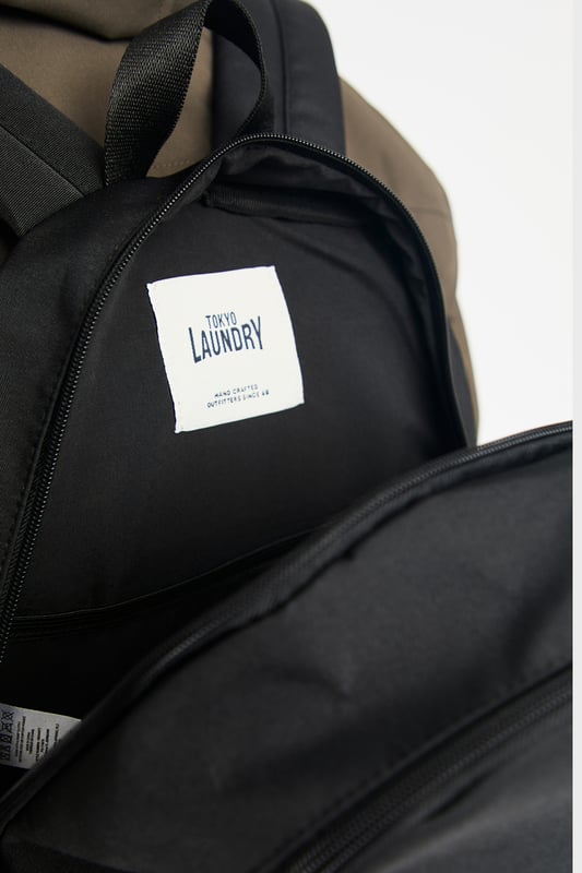 Black Multi Compartment Backpack This basic black backpack from Tokyo Laundry features striking red detailing on the zip and a signature Tokyo Laundry badge. Perfect for everyday use, it combines style and practicality with spacious compartments and durable design. A sleek, functional accessory for carrying your essentials in style.