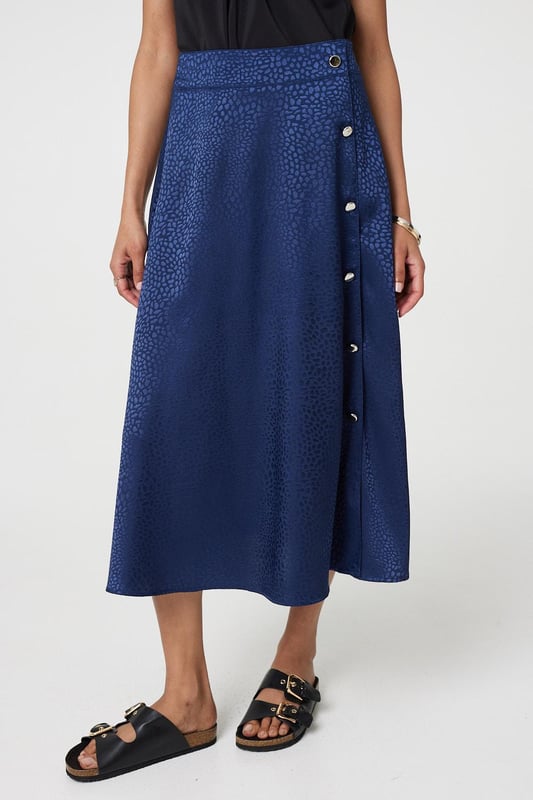 This elegant skirt has a silky satin texture with a flattering a-line cut. It fastens with button details and has a high waist fit, with a midi length hem. Tuck your favourite t-shirt, top or jumper into the waistband for an elevated casual look.