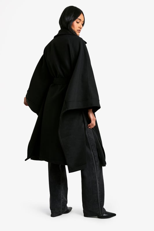 Dramatic cape-style silhouette for a bold statement
        Oversized collar adds a touch of sophistication
        Belted waist for a customisable fit
        Functional side pockets for practicality
        Versatile length suitable for various outfits
    
    Make a striking entrance with this captivating cape in wool-look fabric. Perfect for the fashion-forward woman who craves both style and comfort, this piece effortlessly combines drama with versatility. The oversized collar and flowing silhouette create an air of elegance, while the belted waist allows you to customise your look. Ideal for casual outings or family gatherings, pair it with wide-leg trousers and a simple top for a chic ensemble. The side pockets add a practical touch, making it perfect for those days when you want to travel light. Whether you're heading to a coffee date or a weekend market, this cape will ensure you stand out from the crowd while keeping you cosy. Its adaptable nature means it can be dressed up or down, making it a valuable addition to any wardrobe.