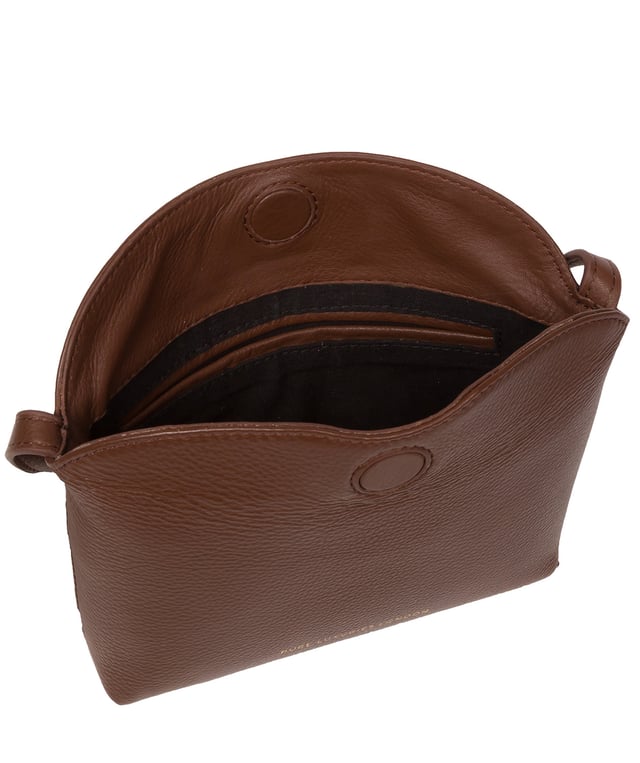 The 'Lolo' cross body bag from the Pure Luxuries Marylebone collection is handcrafted from high-quality, genuine Nappa leather with a natural super-soft touch. The bag is secured by a magnetic closure which opens to reveal a 100% cotton-lined interior and includes two slip pockets. Features gold-coloured metal fittings alongside the adjustable slim leather strap, with a maximum drop length of 65cm. The Pure Luxuries logo is embossed in gold foil for a beautifully simple finishing touch.