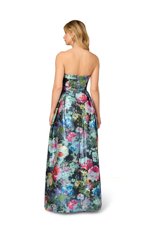 Luxurious details elevate this metallic floral ball gown. This evening gown features a fitted bodice with boning for structure, a strapless straight neckline with fold over detail, and a full ball skirt. Designed from floral print metallic jacquard fabric imported from France, this ball gown has crinoline under the pleated skirt for added volume. A hidden zipper closure at the centre back and pockets within the skirt completes this strapless gown. A perfect look for a black-tie event or formal wedding, this floral gown looks great when paired with nude heels and a statement-making clutch.
