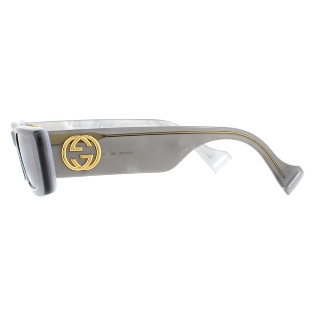 De Gucci-zonnebril GG0516S 002 Grijs Zilver is geïnspireerd op vintage stijl met een gedurfde rechthoekige acetaat montuur. Super dikke tempels zijn versierd met een groot metalen GG logo.