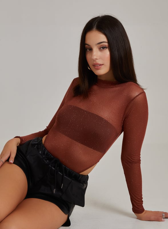 Make a statement this season with this Glitter Long Sleeve Bodysuit. Add this to any outfit for an insta-worthy 'fit. Pair with flares and strappy heels for an easy, chic style.