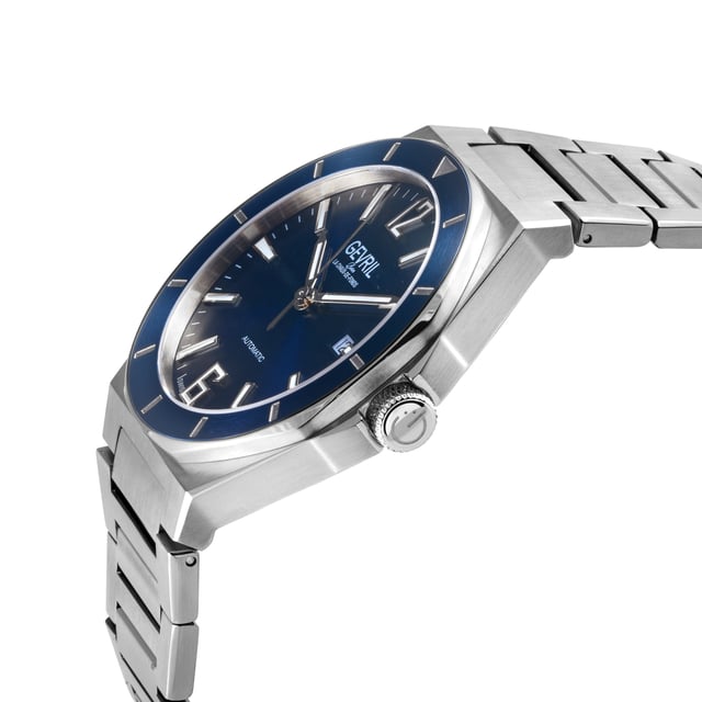 Like a moment of solitude amongst the chaos, Gevril’s High Line Collection is an automatic timepiece with historical roots and sound modern design. Named after Manhattan’s historical High Line park – a nearly 1.5 mile elevated sanctuary of greenery built on a historic steel railway – this collection inspires the cool, calm and collected feel of a walk in the park.   With clean lines and an expert use of space, the High Line collection features Swiss automatic movement encased by 43mm of pure stainless steel. The unencumbered watch face in Forest Green, Navy, Black, Brown or Silver implies that simplicity well constructed is not to be underestimated. The sunray dial, an ode to the outdoor greenway, and a dark colored bezel reminiscent of the original West Side railway add solid touches to structural integrity. Numbers 6 and 12 on the dial denote the middle and end of the path while the date viewing window at 3 evokes memories of overlooking 10th Avenue.   A modern take with historical references, this collection is elevated and understated – if relaxed and sharp were a watch, the High Line would be it. Because architecture doesn’t have to be complicated to be monumental: the High Line collection. 
Gevril 48401B Men's High Line Swiss Automatic Watch
Gevril Men's Automatic Watch from the High Line Collection
43mm Round 316L Stainless Steel Case, Blue Bezel, Blue Sunray Dial
Push/Pull Crown, Date at 6:00
Exhibition Case back
316L Stainless Steel Bracelet with Deployment Buckle
Anti-reflective Sapphire Crystal
Water Resistant to 100 Meters/10ATM
Swiss Automatic, SW200 Movement