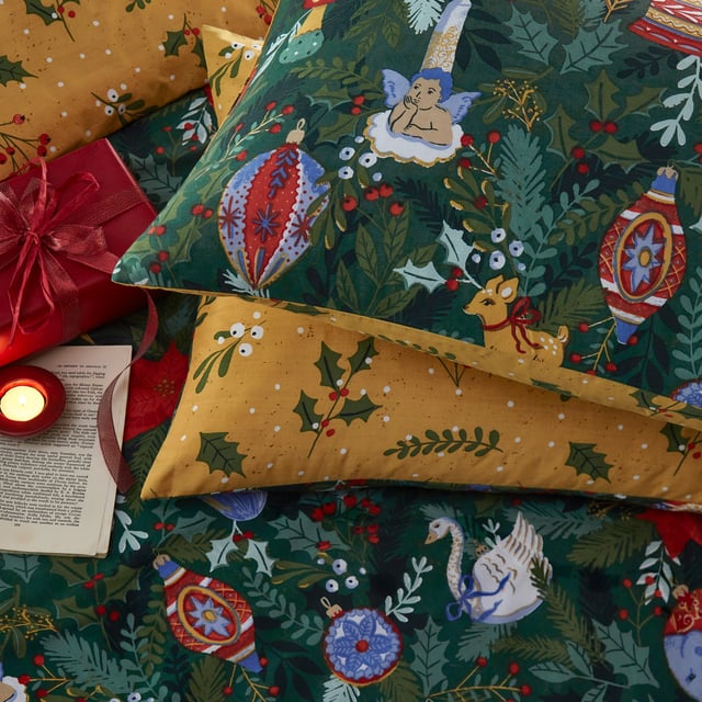 Get into the Christmas spirit with this Deck The Halls bedding. Featuring an intricate design of traditional festive trinkets on a backdrop of foliage and greenery. A scattered design of boughs of holly covers the reverse giving you two looks in one!