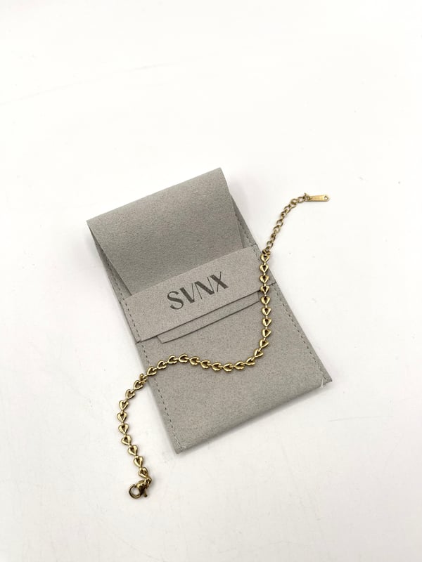 Heart Link Bracelet in Gold. A timeless piece with a delicate heart link design, blending subtle charm with refined elegance. Perfect for daily wear or special occasions, this bracelet adds a sophisticated touch to any outfit. 
Size: 16cm + 4cm
Stainless steel, Gold Plated
Colour: Gold
Pouch included