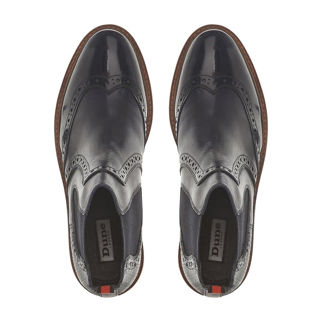Dune Ladies PALOMO Punched Chelsea Ankle Boots Make a statement with the Palomo Chelsea boot from Dune London. Designed with classic stretch panels and timeless brogue detailing. Showcasing a chic patent finish, it's complete with a rear pull tab.