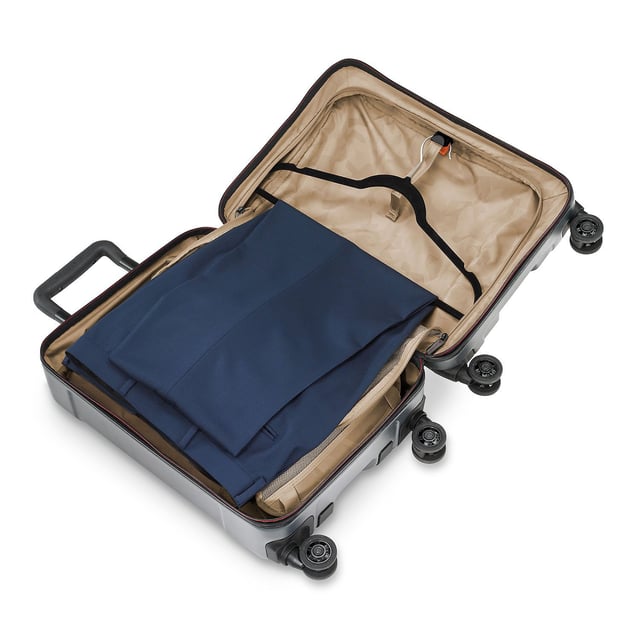 Stop fumbling with zippers and cords and switch to our Torq Domestic Carry-On Spinner. With a USB port and patented hinged front pocket, this bag will be your go-to for all destinations. Lightweight and resilient, take it with you to the city or the beach -- wherever you roam. Key features include: Outsider® handle provides greater interior capacity and a smooth surface for packing so clothes arrive wrinkle-free. Monogrammable leather nameplate to customise with your initials; easily removable and replaceable. External USB port on side of bag connects to a separate battery stored in front pocket, conveniently letting you charge your phone or other device from outside the bag. Integrated padded laptop sleeve in front compartment protects most 15" laptops. Padded tablet slip pocket in front compartment protects most 10.5" tablets.