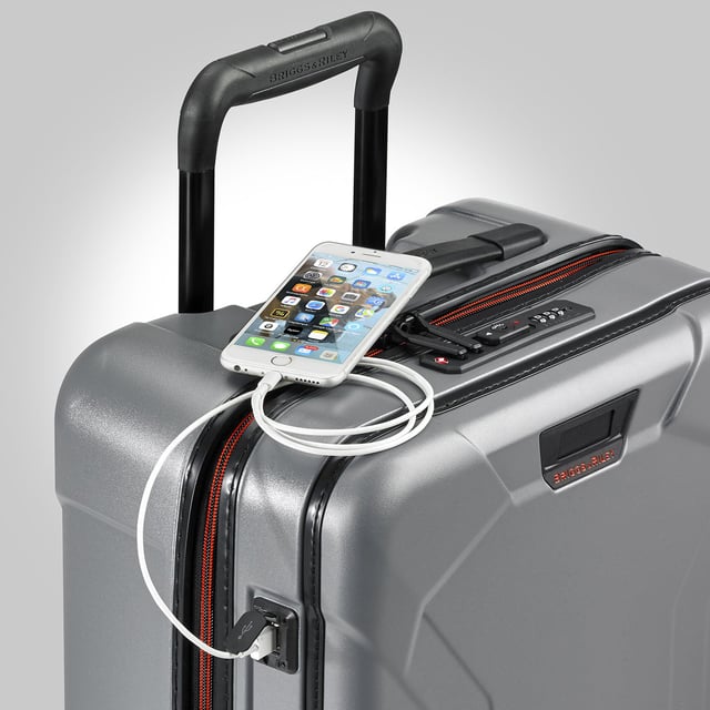 Stop fumbling with zippers and cords and switch to our Torq Domestic Carry-On Spinner. With a USB port and patented hinged front pocket, this bag will be your go-to for all destinations. Lightweight and resilient, take it with you to the city or the beach -- wherever you roam. Key features include: Outsider® handle provides greater interior capacity and a smooth surface for packing so clothes arrive wrinkle-free. Monogrammable leather nameplate to customise with your initials; easily removable and replaceable. External USB port on side of bag connects to a separate battery stored in front pocket, conveniently letting you charge your phone or other device from outside the bag. Integrated padded laptop sleeve in front compartment protects most 15" laptops. Padded tablet slip pocket in front compartment protects most 10.5" tablets.