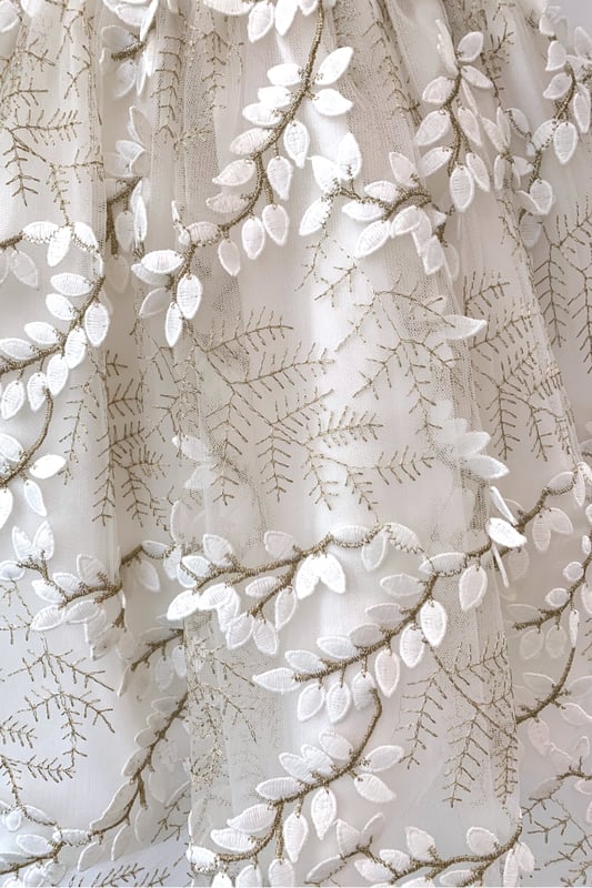 Another new style for us this year. We are so excited to have sourced the beautiful fabric for this style LUCY.

Fern style embroidered leaves in ivory, attached by gold thread stems. The gold catches in the light as the skirt moves and has a 3D effect which makes the leaves look realistic. A very distinctive fabric makes this girls special occasion dress quite unique. You won't see another dress like this on the high street!

The top of the dress is made using our 'Mock Silk' fabric and has a pin tucked sash that ties at the back in a big bow. It's fully lined in lightweight soft 100% cotton, just in case your little one has sentitive skin and also helps them not to get too sweaty after all the twirling and pirouetting around. Let's be honest ... all girls will feel like a princess in this!

All our dresses arrive with you on a satin padded hanger to help keep the dress in the best shape and then protected by one of our heritage garment keepsake bags
Outer - 100% Polyester
Lining - 100% Cotton
Dry Clean or Hand Wash only