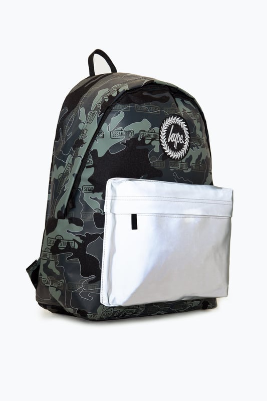 The Hype x Sesame Street Grey Logo Camo Backpack features our signature camo in charcoal, grey and black with the Sesame Street logo on repeat. The front pocket features a reflective fabric for a contrasting look. With a front pocket, puller handle and straps measuring at 42 cms x 30 cms x 12cms, this is the perfect size to transport your essentials. The straps contain the comfort you require with just the right amount of padding. Finished with the iconic HYPE. crest badge in monochrome. Wipe clean only.