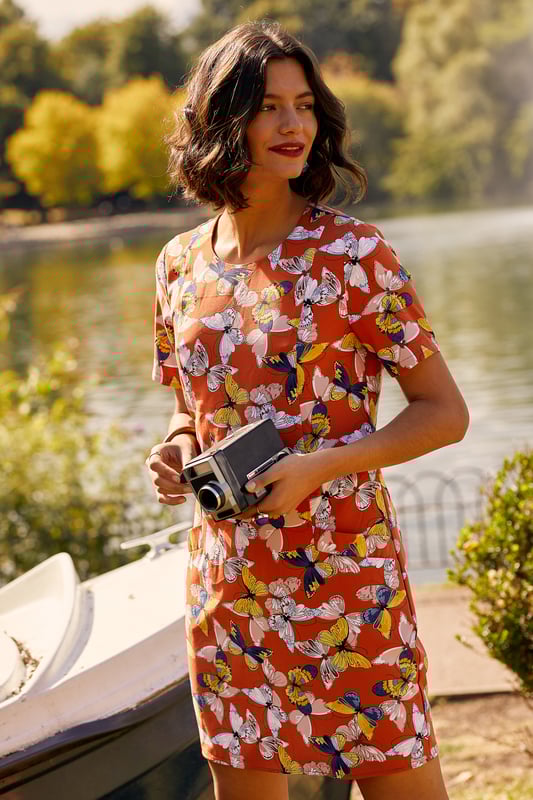 Add something bright to your transitional wardrobe with this Butterfly Tunic Dress With Pocket Detail. Adorned with earthy shades of rust and orange, it's been crafted in a relaxed and easy to throw-on shape with a zip on the back. The short sleeves make it versatile, whilst the practical pockets on the front are ideal for storing your essentials. We're wearing ours with a warm coat and chunky trainers.95% Polyester 5% Elastane. Machine Wash At 30. Length is 90cm/35inches &nbsp;