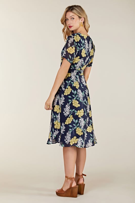 Find your new floral with this must-have Spring Floral Dress With Tie Detail. In the faux-wrap shape that cinches at the waist, it's enhanced by a drawstring that's super-swish and flattering. Our designers have kept the V-neckline elegantly modest, whilst making sure the print is both bright and feminine. Dress it up with wedges and down with trainers. Shell:100% Polyester, Lining:97% Polyester 3% Elastane. Machine Wash At 30. Length 106cm. Model Wears Size 10.