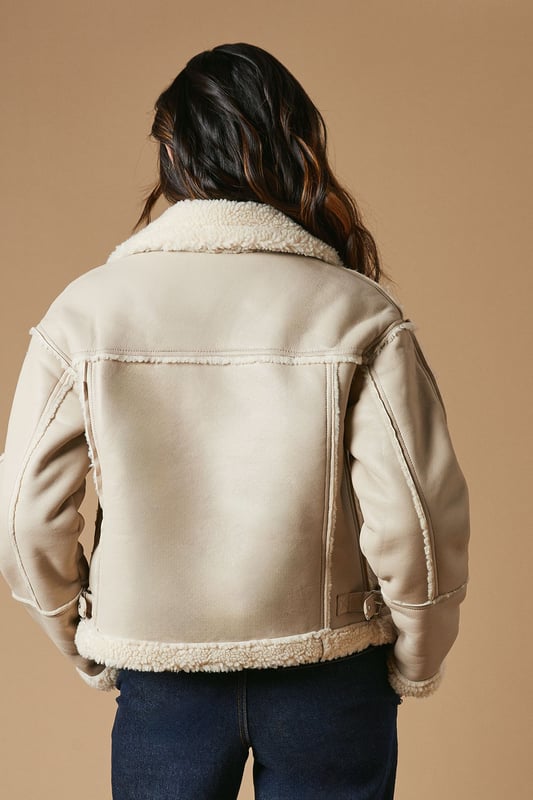 Striking contrast borg detailing for added warmth and style
        Asymmetrical zip front closure for a modern edge
        Oversized collar for a bold, fashion-forward look
        Cropped length perfect for layering
        Versatile design suitable for various casual occasions
    
    This PU borg detail collared zip jacket from Oasis is the epitome of cool-weather chic. The contrasting borg lining not only adds a cosy touch but also creates a striking visual appeal. Its asymmetrical zip closure and oversized collar lend a contemporary edge to your ensemble. The cropped silhouette is ideal for showcasing high-waisted bottoms, as demonstrated by the model pairing it with wide-leg trousers. For a casual day out, style it with your favourite jeans and trainers. Alternatively, dress it up for an evening with friends by layering it over a fitted dress and ankle boots. This jacket is a versatile piece that will quickly become a go-to in your autumn and winter wardrobe, perfect for family gatherings, weekend brunches, or casual outings where you want to make a stylish statement without compromising on comfort.