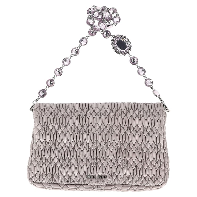 VINTAGE, UVP WIE NEU  
Verleihen Sie Ihrem Stil mit der Miu Miu Large Crystal Cloque Schultertasche aus edlem grauem Nappaleder das gewisse Etwas. Diese exquisite Tasche besticht durch ein atemberaubendes Design mit Kristallen, das jedem Outfit einen Hauch von Glamour verleiht. Das geräumige Innere bietet ausreichend Platz für Ihre Essentials, während das weiche Nappaleder ein luxuriöses Gefühl garantiert. Perfekt für Tag und Nacht, vereint diese Schultertasche mühelos Eleganz und Funktionalität und macht sie zu einem unverzichtbaren Accessoire für die moderne Frau.

Miu Miu Large Crystal Cloque Schultertasche aus grauem Nappaleder

Zustand: Sehr gut  
Abnutzungsspuren: Kein Verkaufsetikett, Geringe Abnutzungsspuren, leichte Faltenbildung  
Verpackung: Staubschutzbeutel  
Farbe: Beiger Print  
Material: Leder | Schafsleder  
Größe: Einheitsgröße  
Maße: Breite: 30; Höhe: 220; Länge: 360  
SKU: NAPPUGBBA403346W