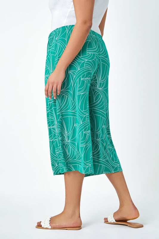 Curve Abstract Swirl Stretch Cropped Culottes from Roman. Say hello to your new favourite staple piece in a bold abstract print. Roman Curve's new and stylish wide-leg culottes are everything you need. Soft stretchy jersey fabric and an elasticated waist make these floaty trousers comfortable and wearable throughout the season. Our casual pull-on bottoms are so versatile, wear with our matching top (19292234) for a striking daytime style.