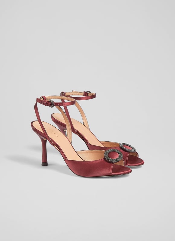 LK Bennett Belle Formal Sandals, Burgundy An elegant and timeless take on a party sandal, our Belle sandals have a glamorous, vintage feel. Crafted from lustrous burgundy satin, they're a peeptoe style with a sparkling, oval-shaped crystal buckle embellishment, a delicate ankle strap and a shapely stiletto heel. Wear them with your favourite party dresses or to instantly dress up a pair of tailored trousers.