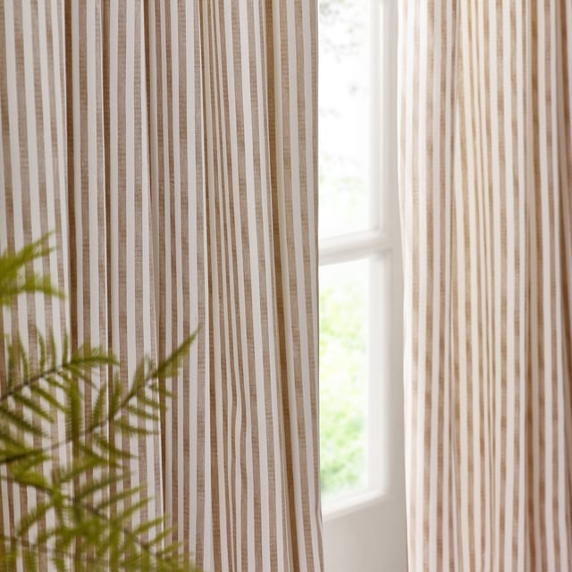 Transform your living space into a sanctuary with Hebden Striped Pencil Pleat Curtains. Crafted from 100% cotton, these curtains offer a soft, yet durable touch. The timeless, textured stripe design complements any minimalist or classic décor, while the room-darkening lining provides the perfect retreat from the outside world. Perfect for those who value natural materials, Hebden curtains are an investment in comfort and style, enriching your home environment without compromise.