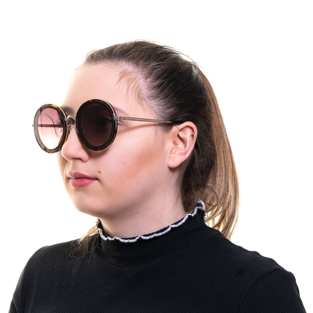 Las gafas de sol Guess GF0330 52F marrón degradado tienen una montura redonda glamurosa y desprenden una sensación de elegancia atemporal. La montura está hecha de acetato de alta calidad, conocido por su durabilidad y ligereza, lo que garantiza una comodidad duradera durante todo el día. Las elegantes patillas incorporan el logotipo de Guess para dar un toque de sofisticación.